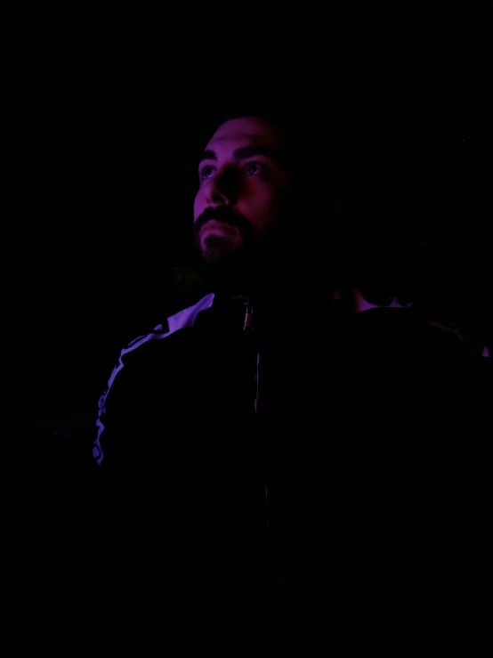 a man sitting in a dark room in the dark