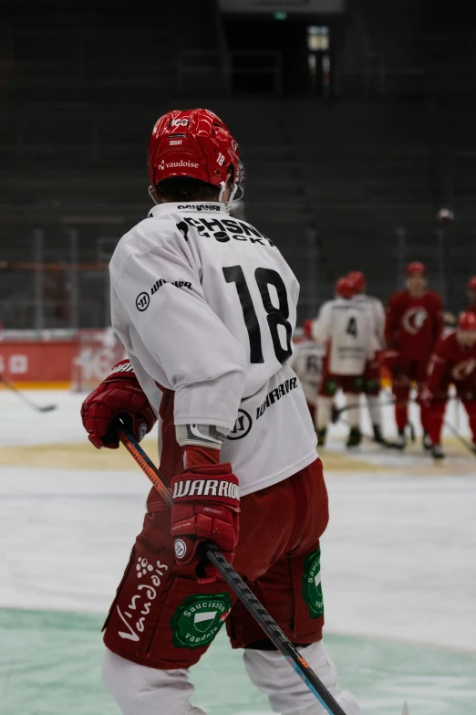 a hockey player on the ice wearing red and white uniform