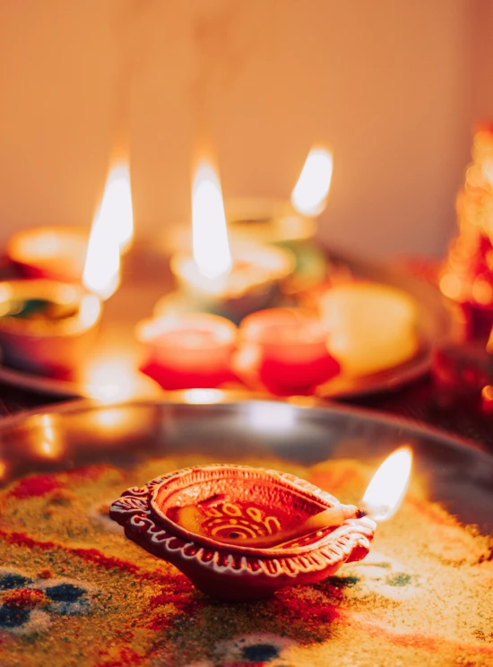 a small candle is sitting on a shiny plate