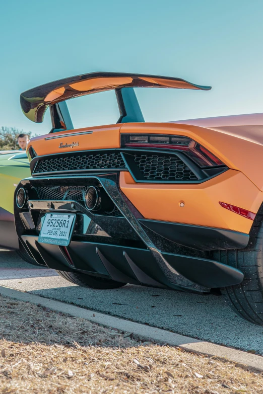 an orange sports car is shown parked in the street