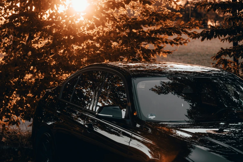 the sun peeking behind a car on the road