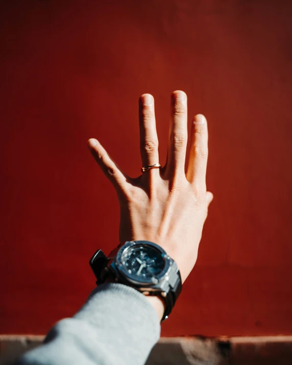 a hand reaching out toward an orange wall