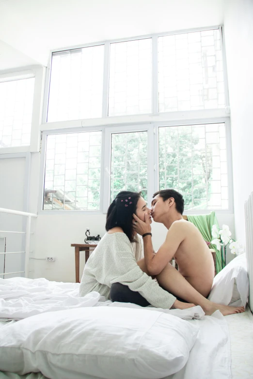 a man and woman sharing an intimate moment on a bed