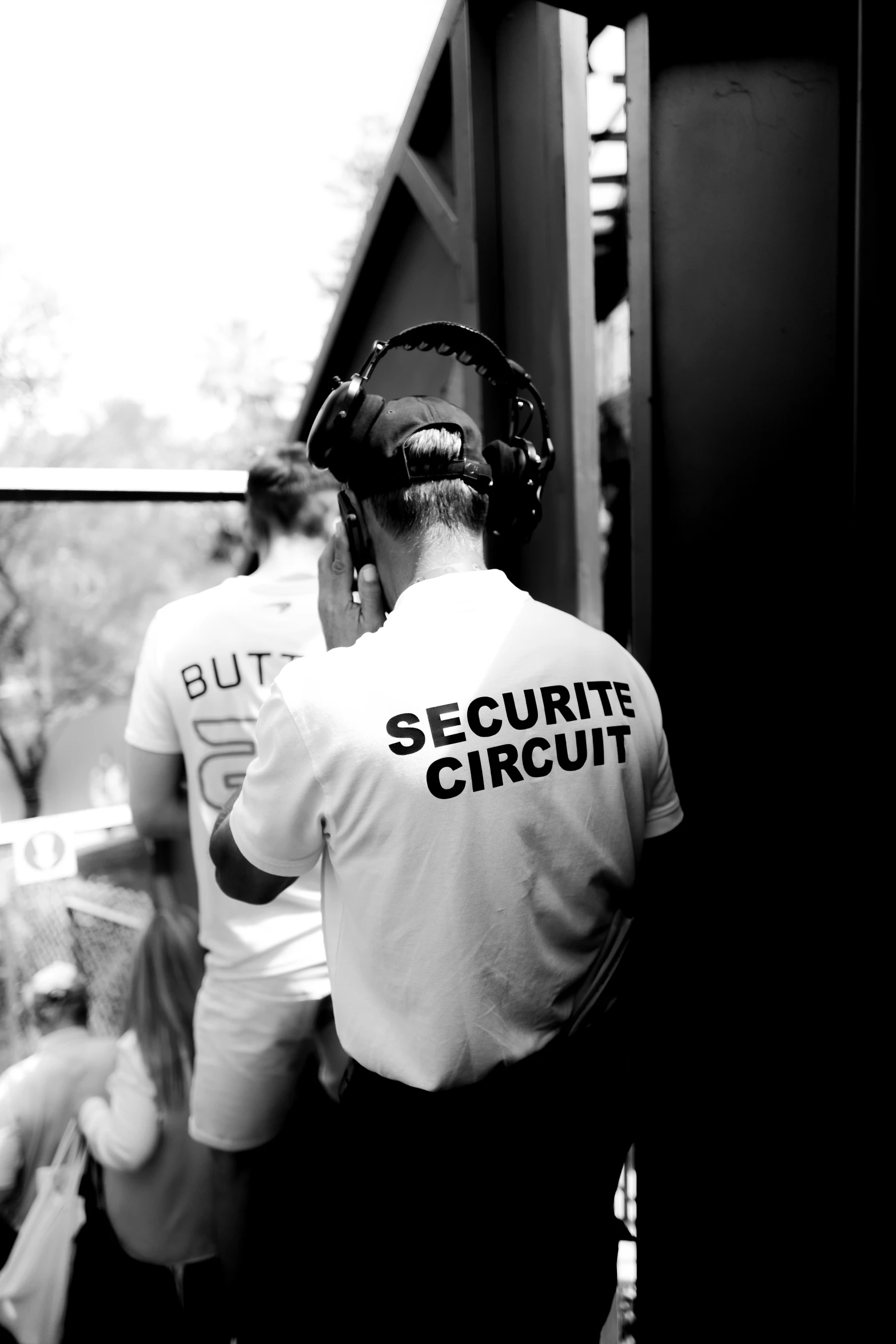 three security people on mobile phones with one holding a book