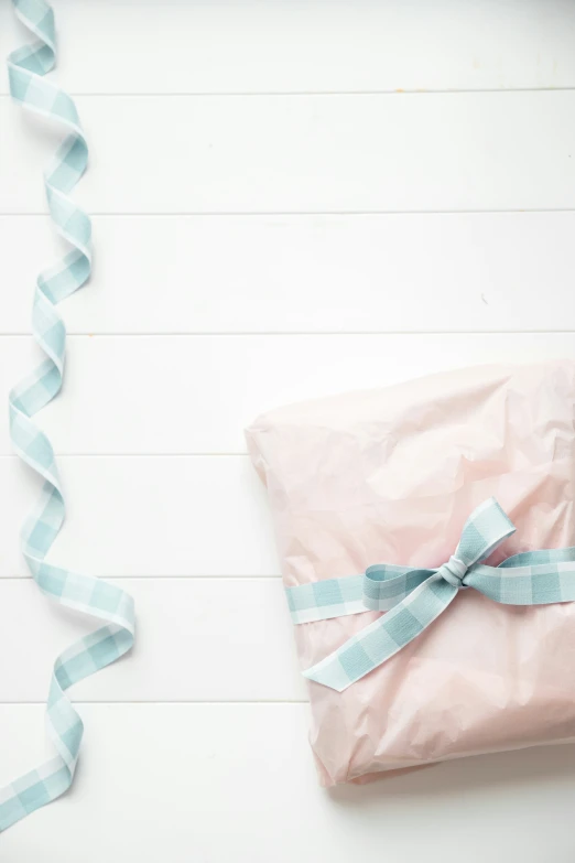 there is a pink wrapping paper with a blue ribbon