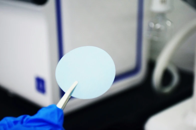 a person in a blue glove is cleaning a computer screen