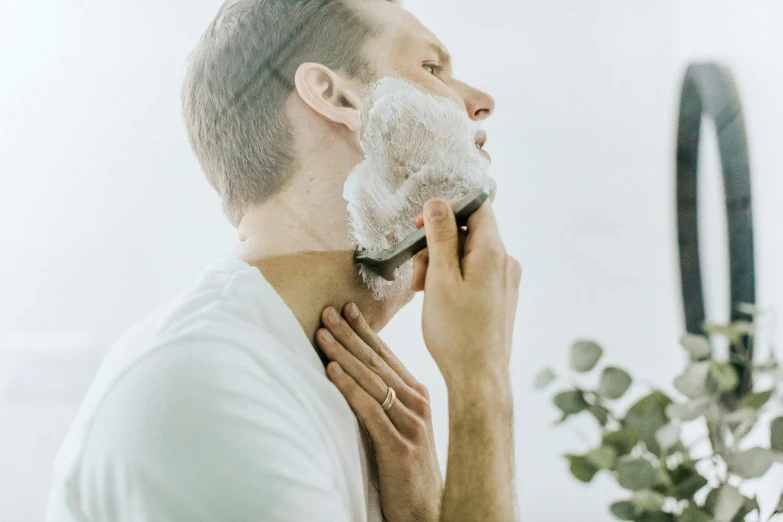 a person shaving a face with a towel