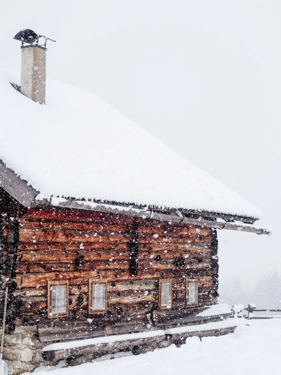 a cabin with windows in the snow covered ground