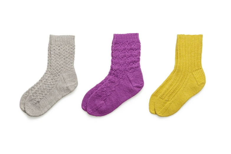 three different color socks on a white background