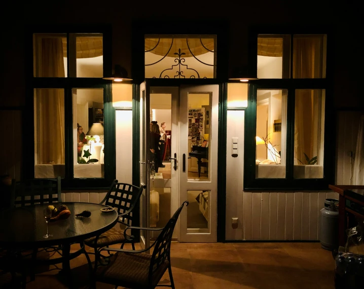 a dining room table with some chairs at night