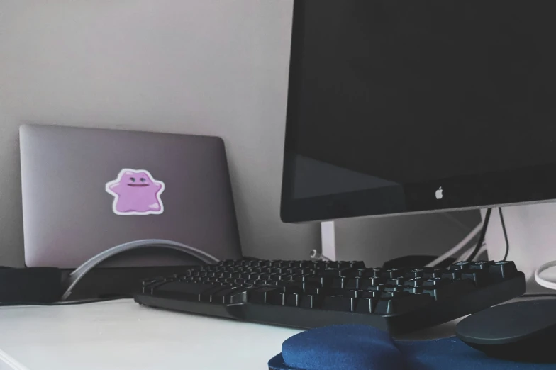 a computer monitor next to a keyboard and mouse