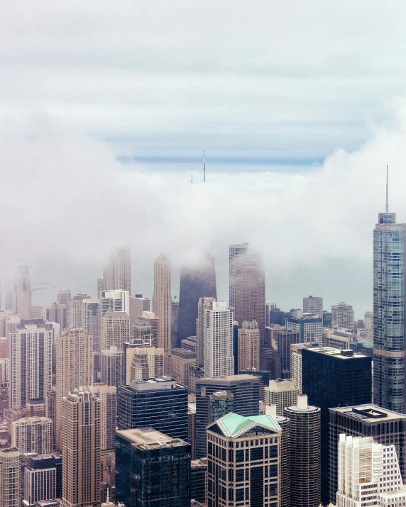 a city filled with tall buildings surrounded by fog