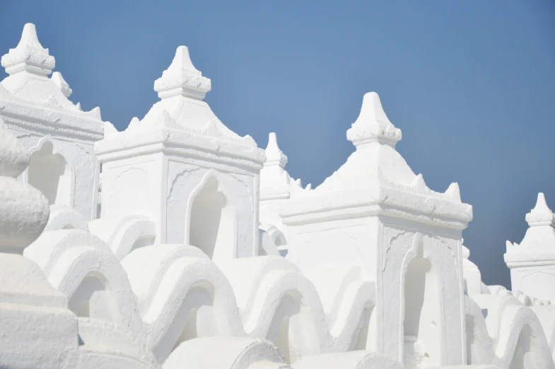 a row of white stucco structures in front of a blue sky