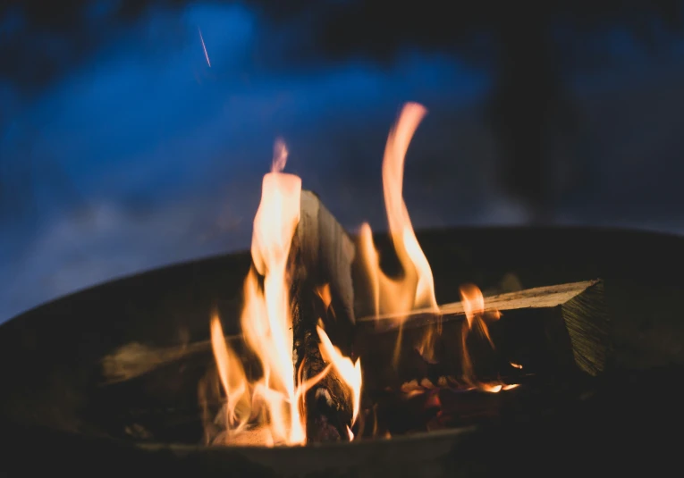 fire in a big pot with flames and blue sky