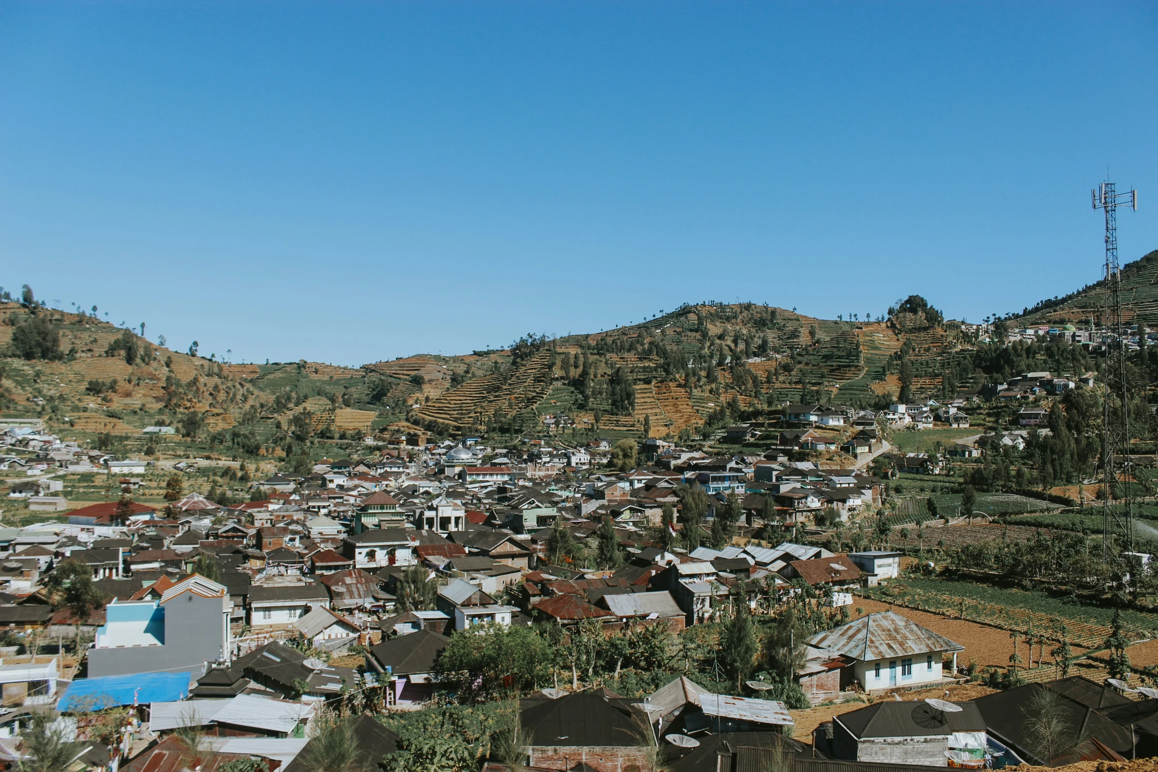 a large area of houses on the hill near some trees