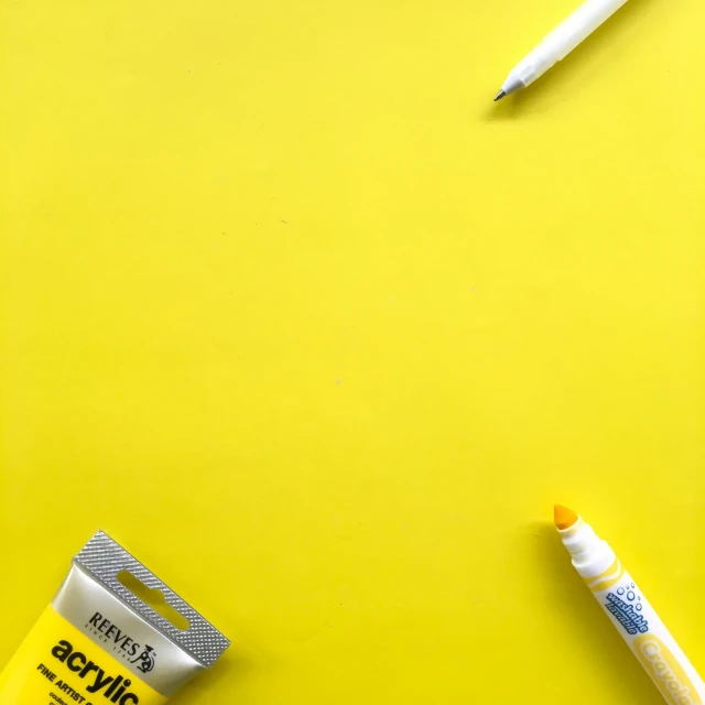 three toothbrushes and a one tube on a yellow surface