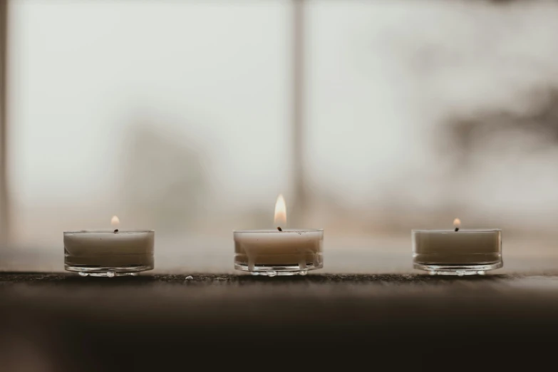 three candles that have been placed together on a table