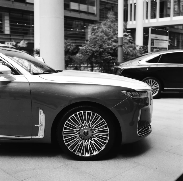 two cars parked on a city street in front of tall buildings