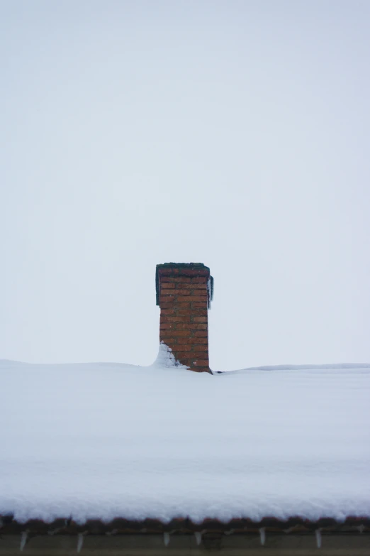 a brick chimney sticking out of the snow