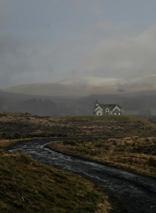 a black and white picture of a house in the country