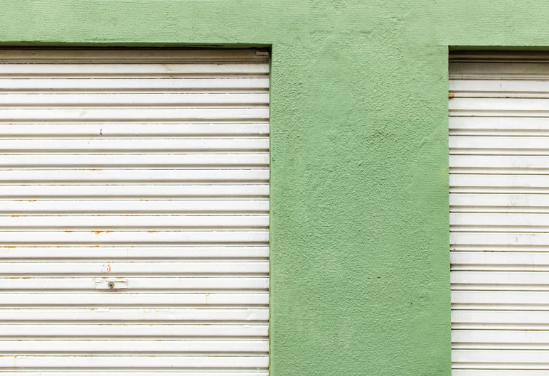 a green garage with a brown fire hydrant