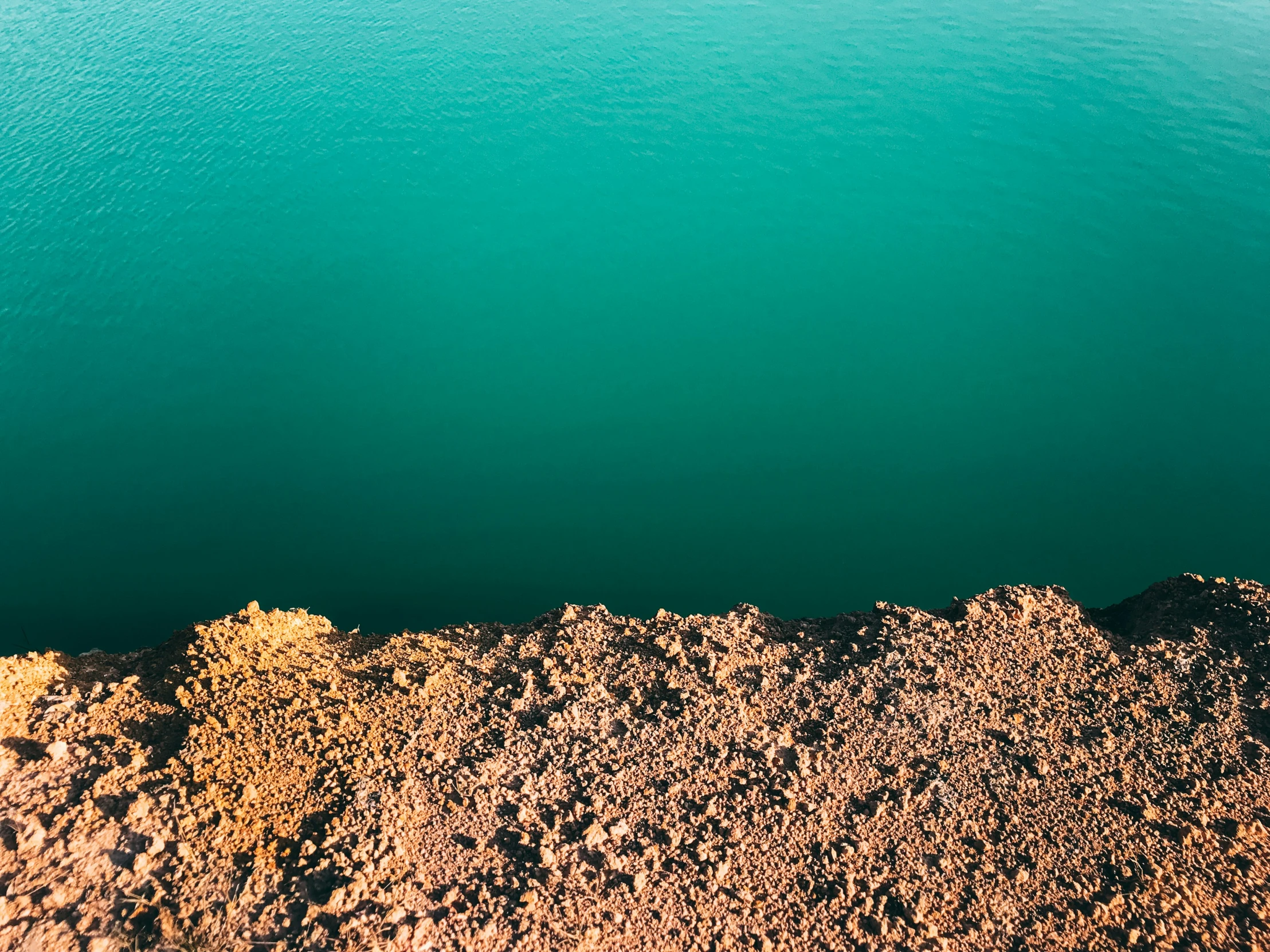 view over a pond in the sand near rocks