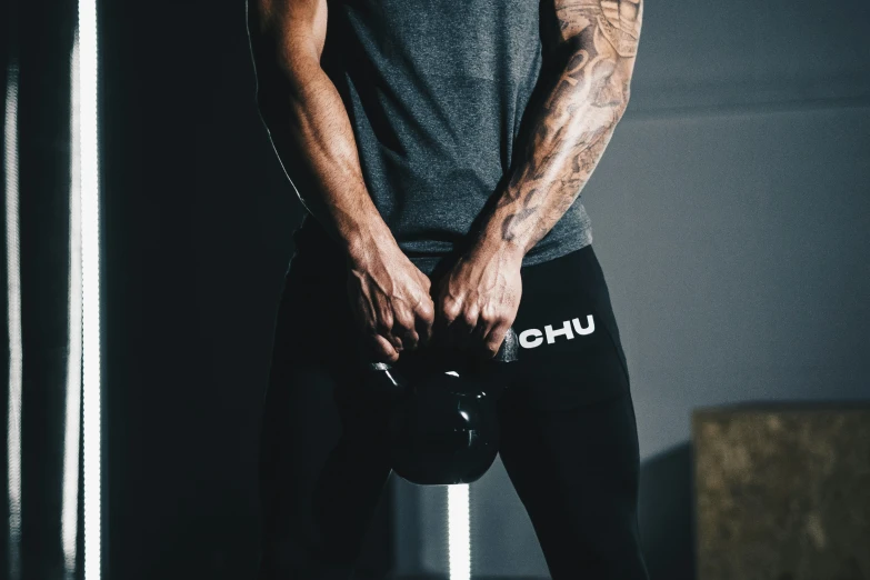 man in a gym shirt holding a kettle