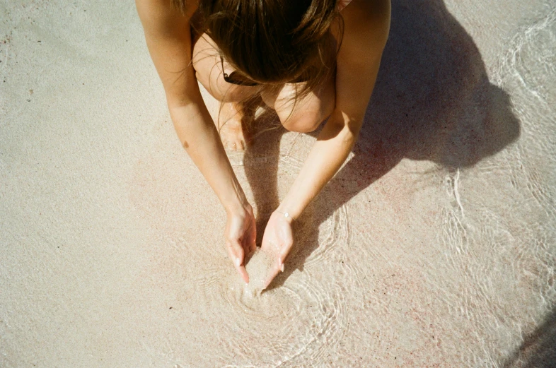 a girl wearing a bathing suit in the sand