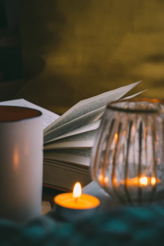 the candles on the table are lit up next to an open book