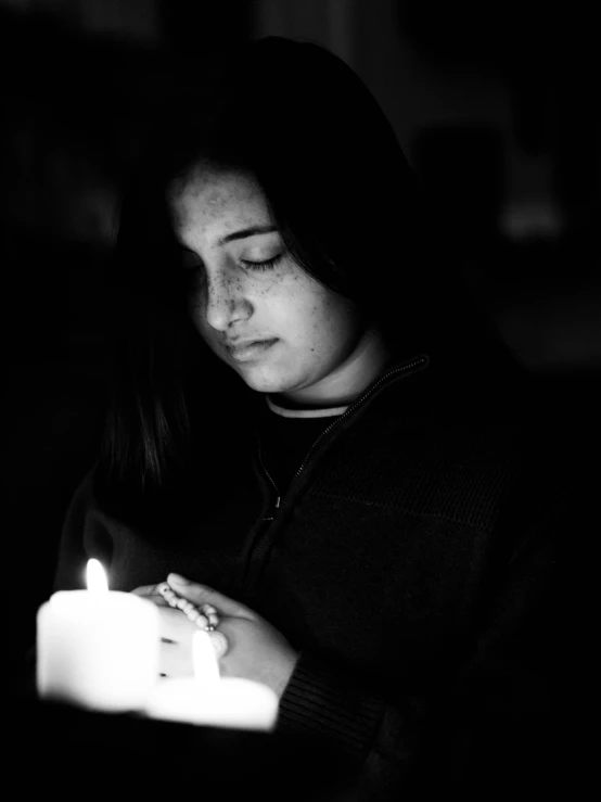 a woman with her face close to a candle