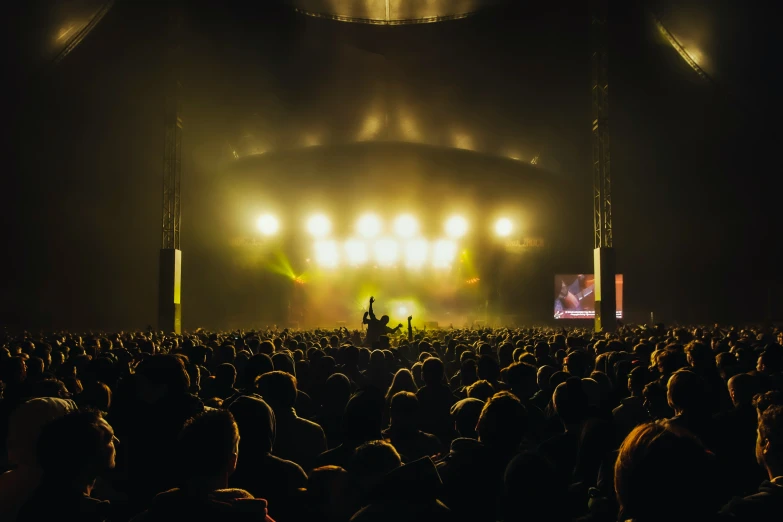 a concert with lights, stage and crowd of people