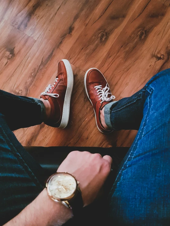 a man holding his wrist as he sits with his foot on the floor