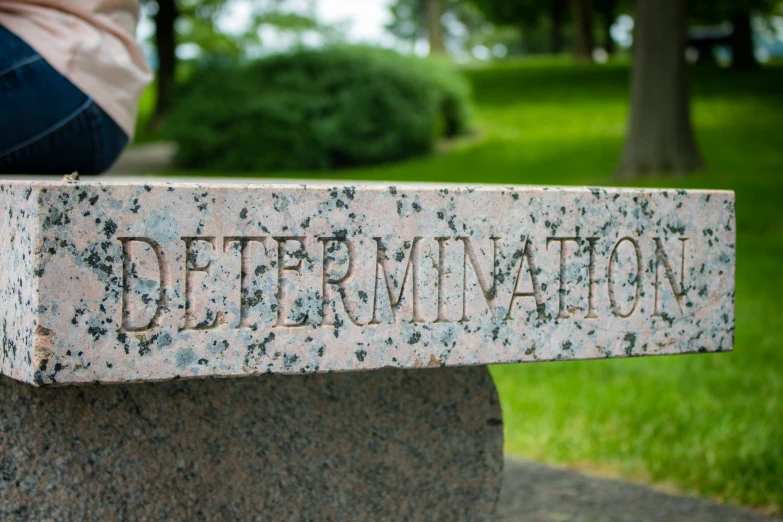 someones legs resting on a rock that says determination