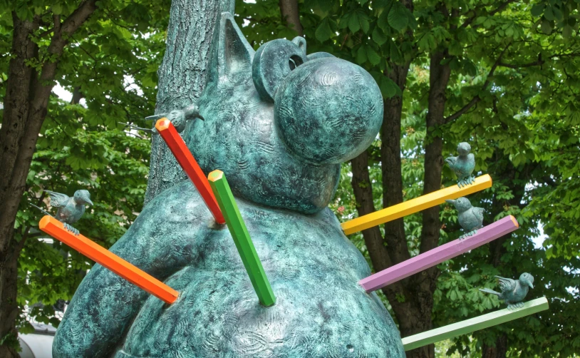 the statue is holding different colored pencils on its back