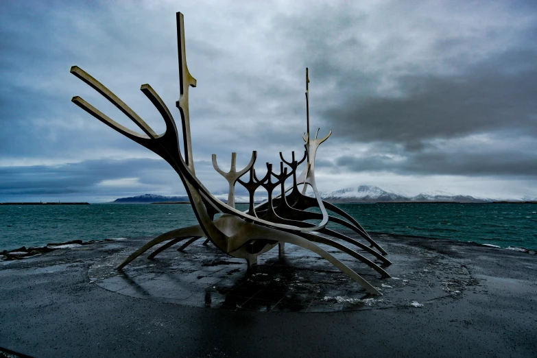 large metal sculptures sit on top of an empty concrete beach