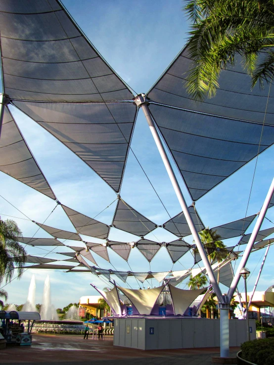 an outdoor structure covered in tarps sits under the blue sky