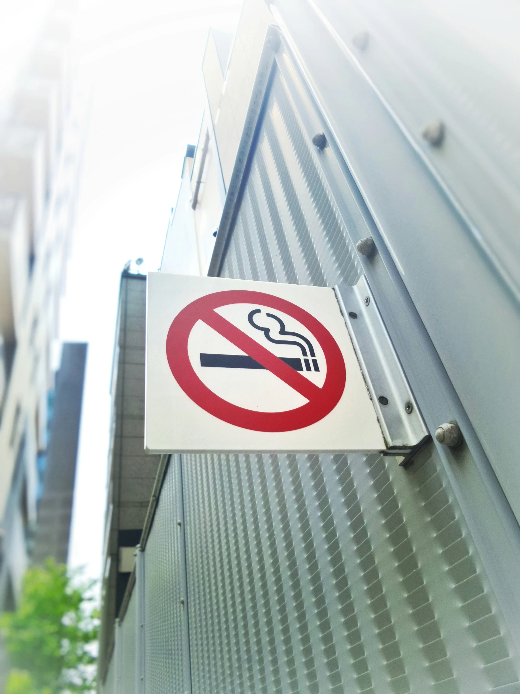 a no smoking sign posted on a metal building