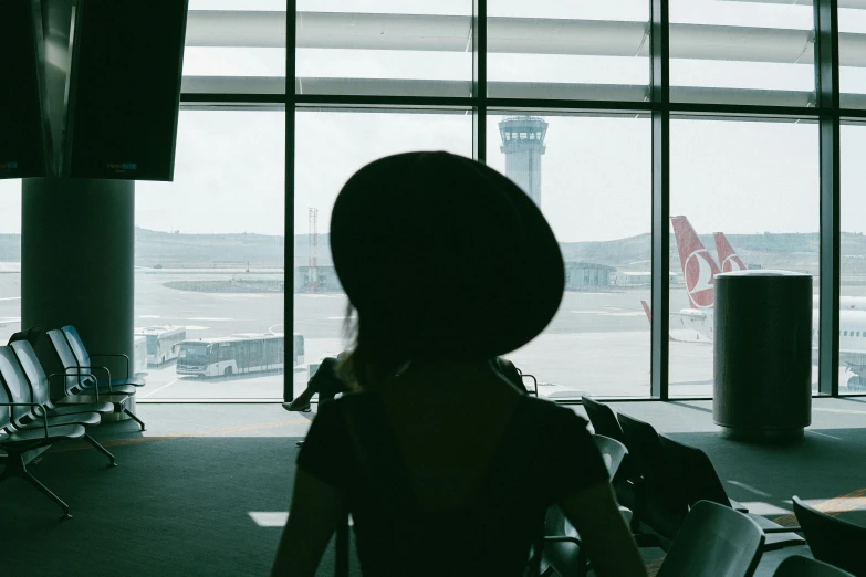 the person is waiting by the window in the airport
