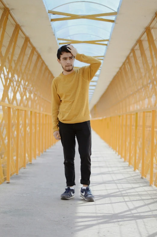 a man is standing on a bridge holding his head