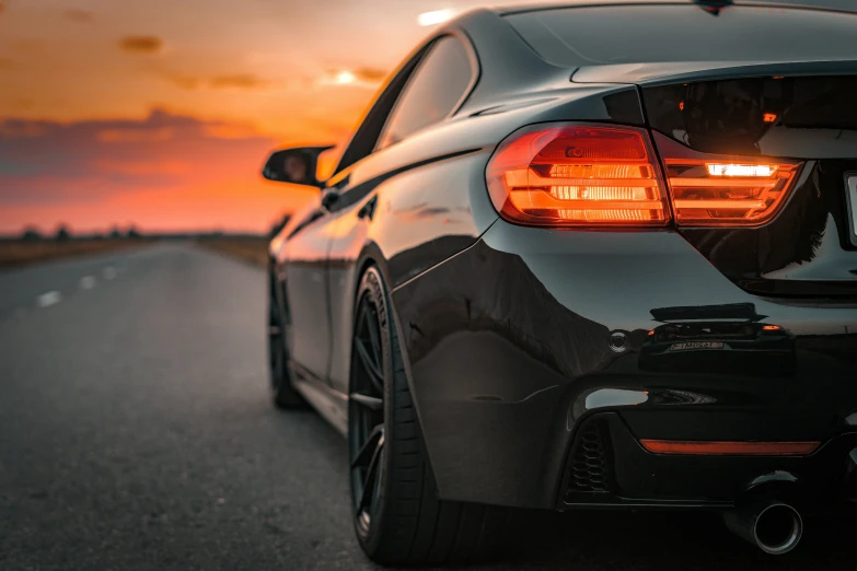 the taillights of a car are on and a road at sunset