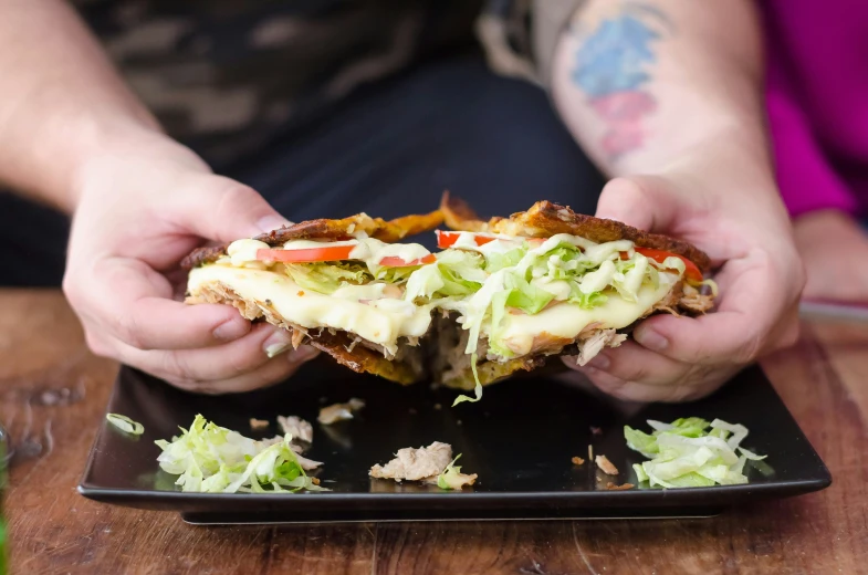 a person grabbing food from a plate on a wooden table