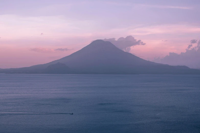 there is a boat in the water near the mountain