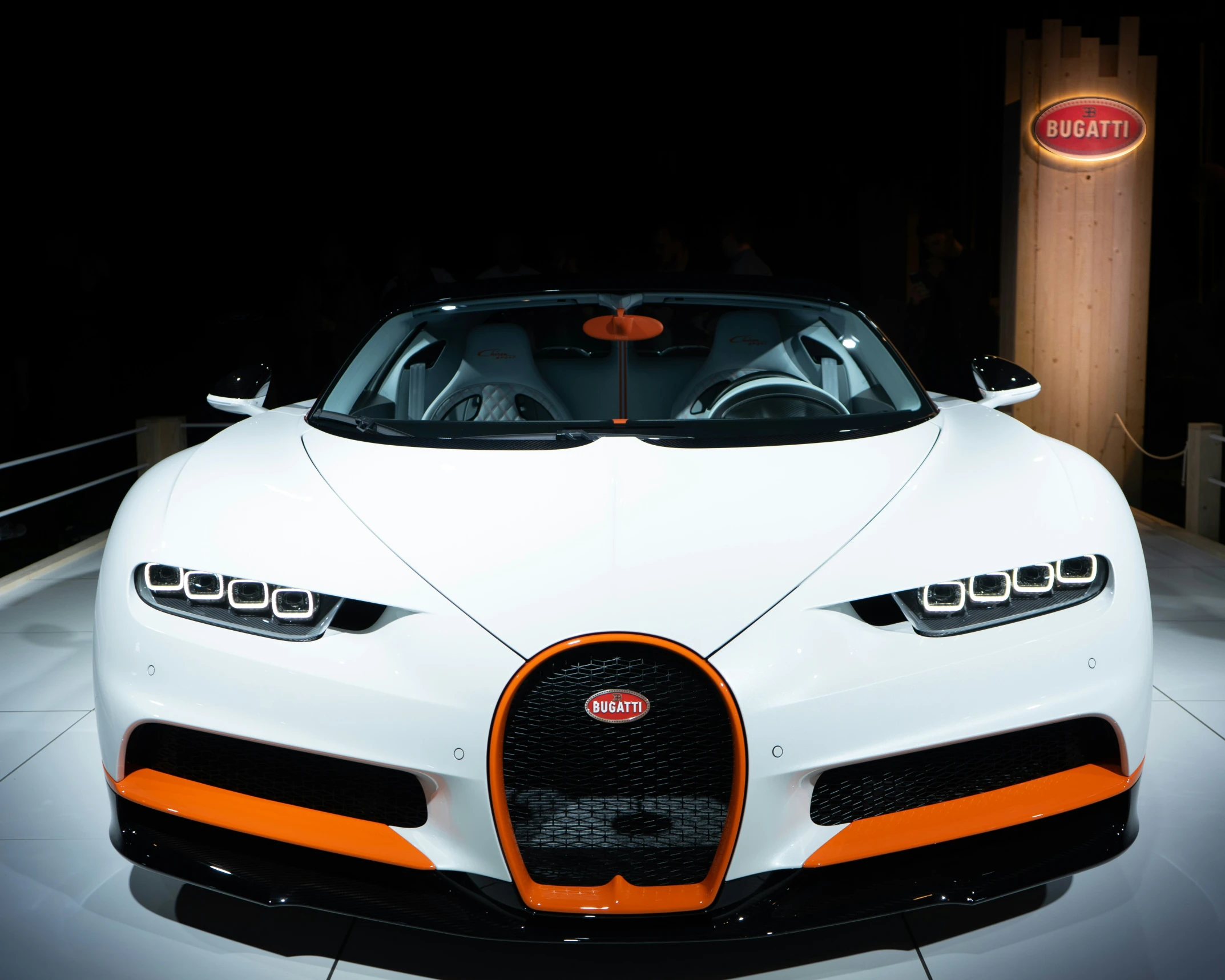 a large white sports car on display at a show