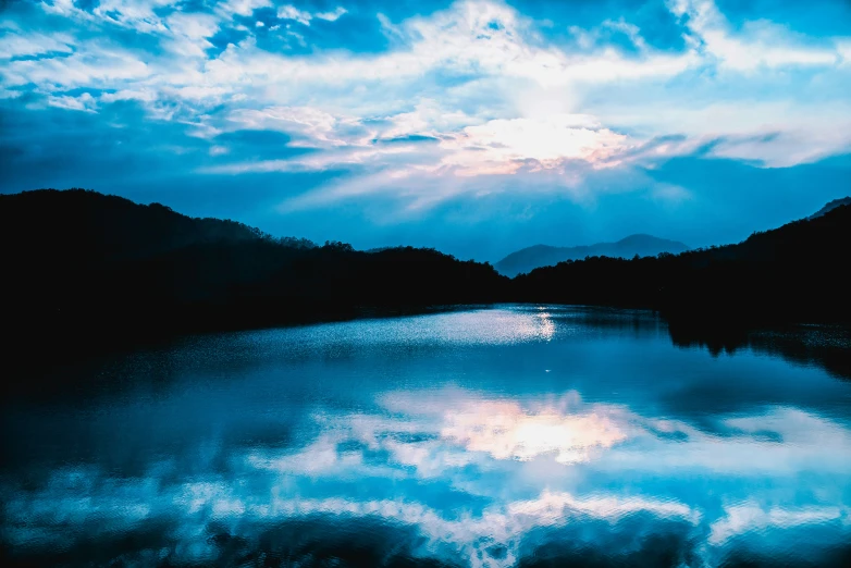 this is a lake with water and clouds in the background