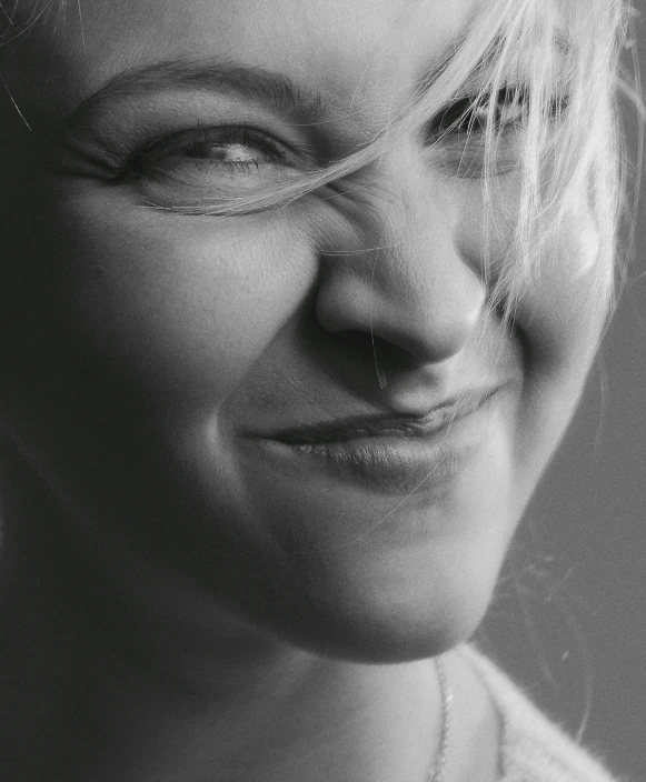 a woman wearing glasses smiles while she poses for the camera