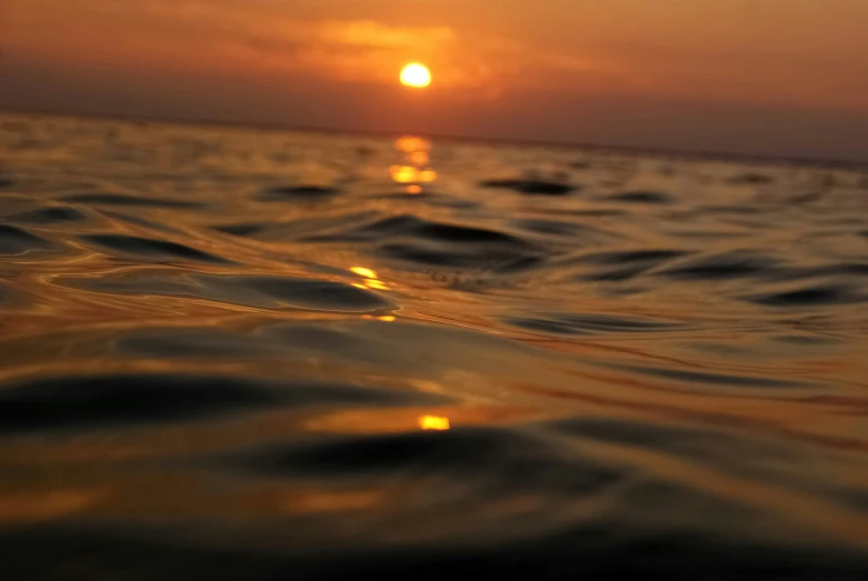 water in the ocean during sunset with the sun setting