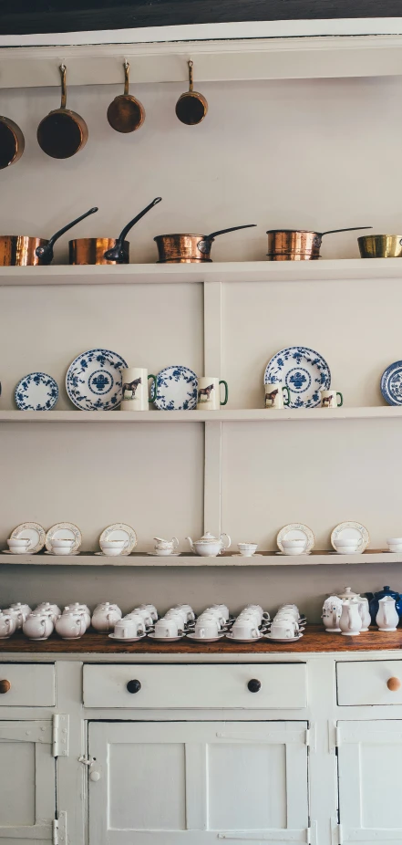 there are many shelves on top of the wall with plates