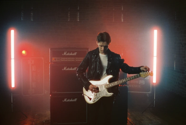 a man is playing an electric guitar and holding it