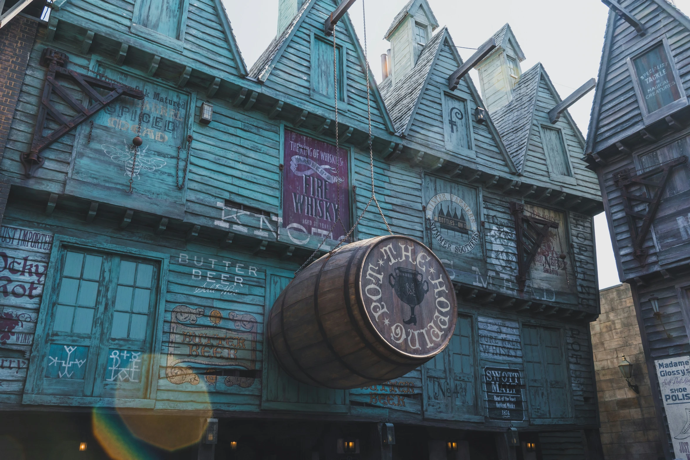 a giant clock hangs from the side of an ornate, weathered building