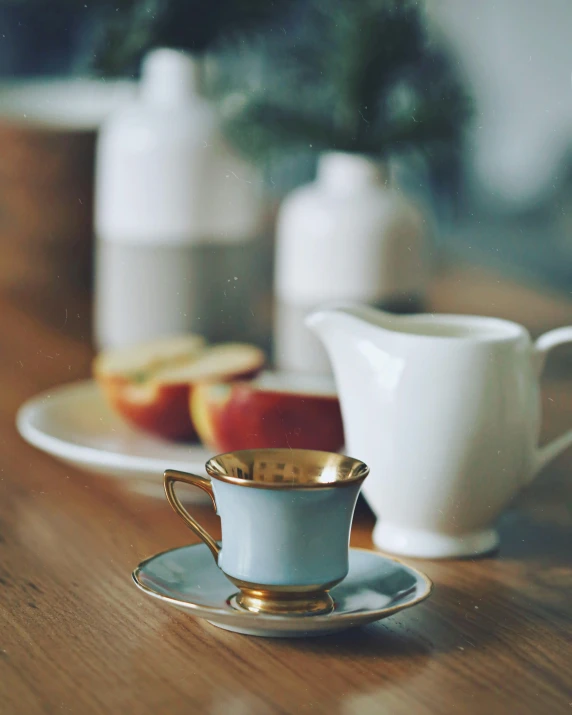 there is a golden cup and saucer on a wooden table